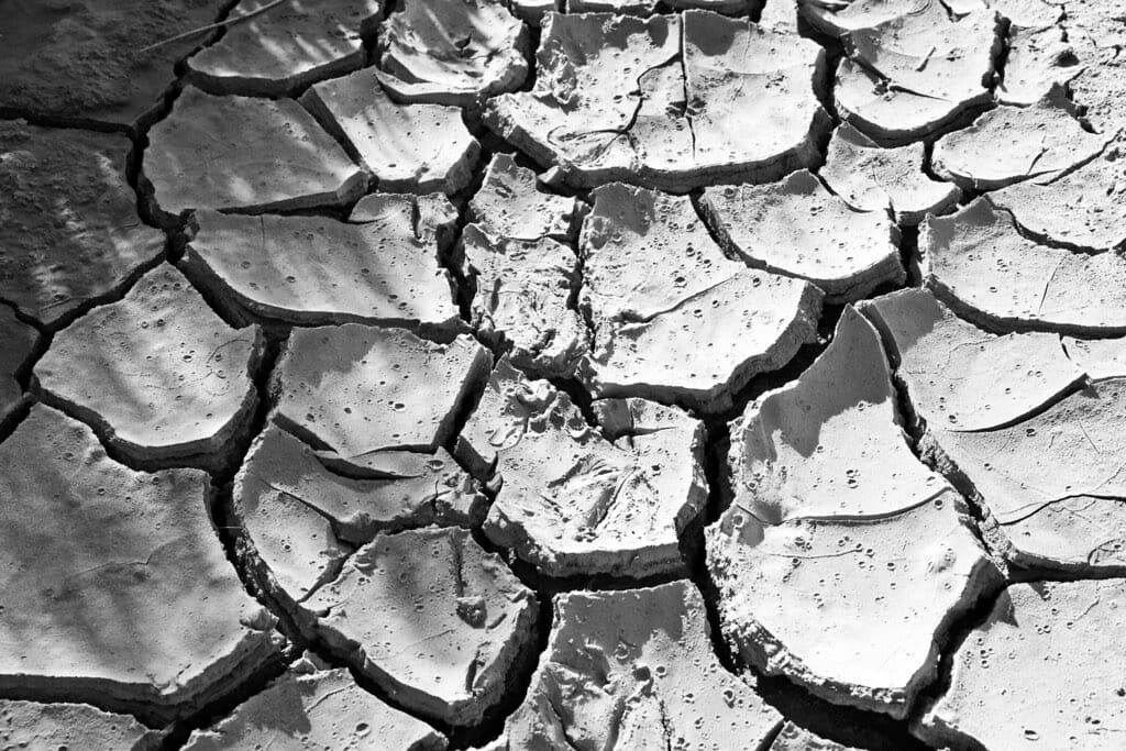 Bare soil broken into deep cracks by sustained heat and no rain